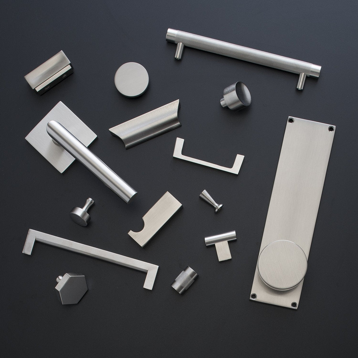 Top view of Edgecliff Pull showcasing its textured cylindrical bar among assorted hardware on a dark background