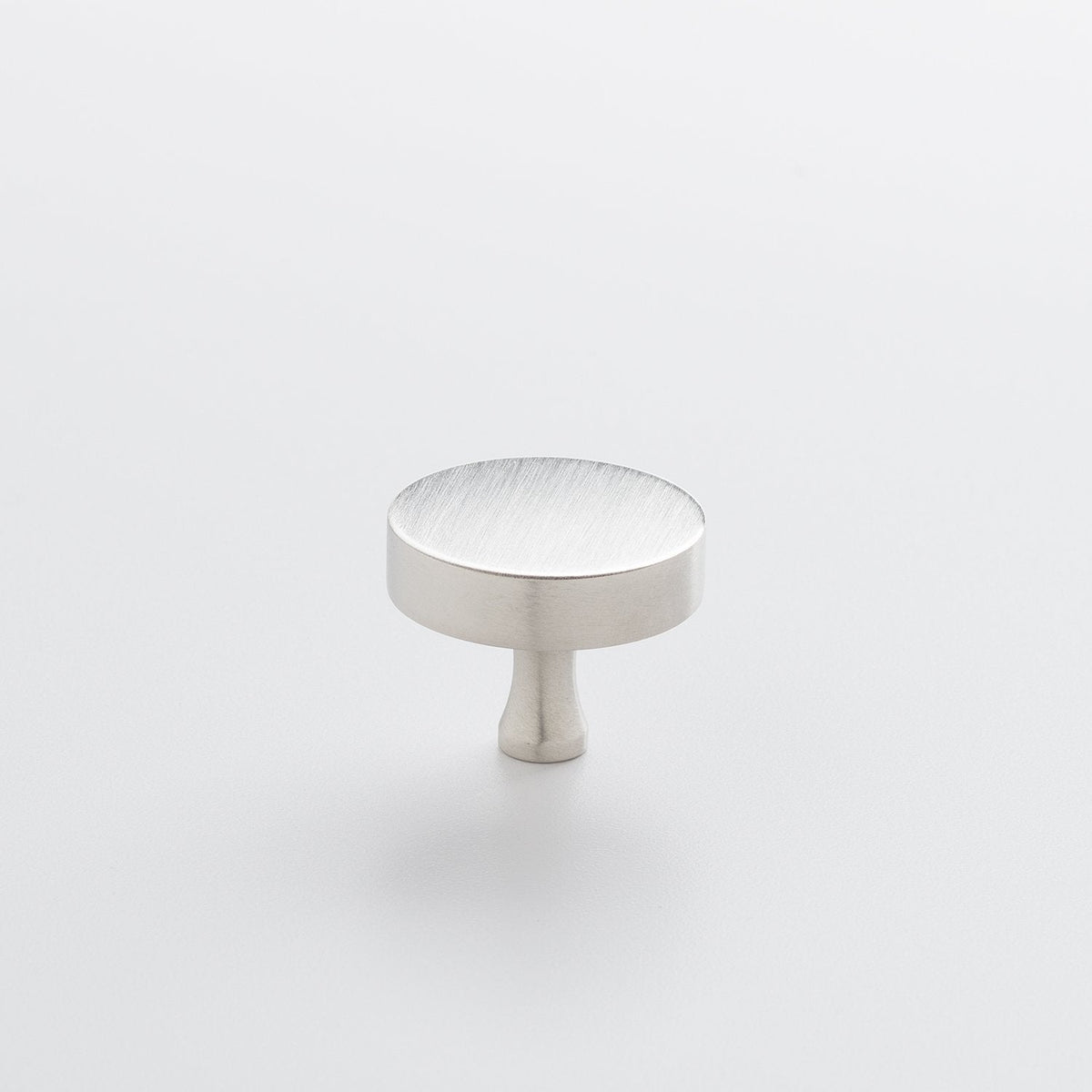 Three-quarter view of the Satin Nickel Riverwood Knob showcasing its flat round top and fluted neck on a light background