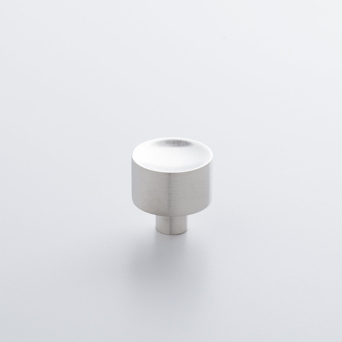 Angled view of Mid Century Knob showcasing a brushed silver finish with a light gray background