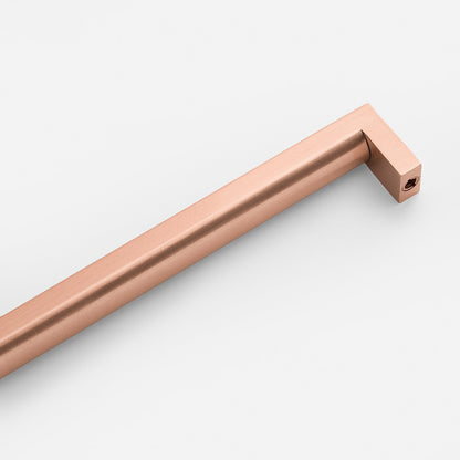 Angled view of Edgecliff Appliance Pull showcasing a copper-toned finish and squared ends on a white background