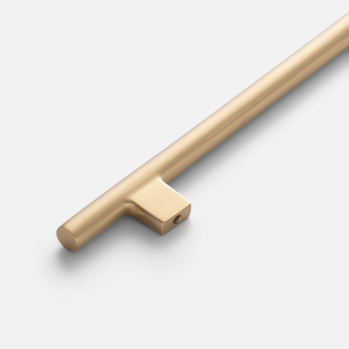 Close-up view of the Galley Pull in natural brass showcasing asymmetrical intersecting curves and its back-plate on white