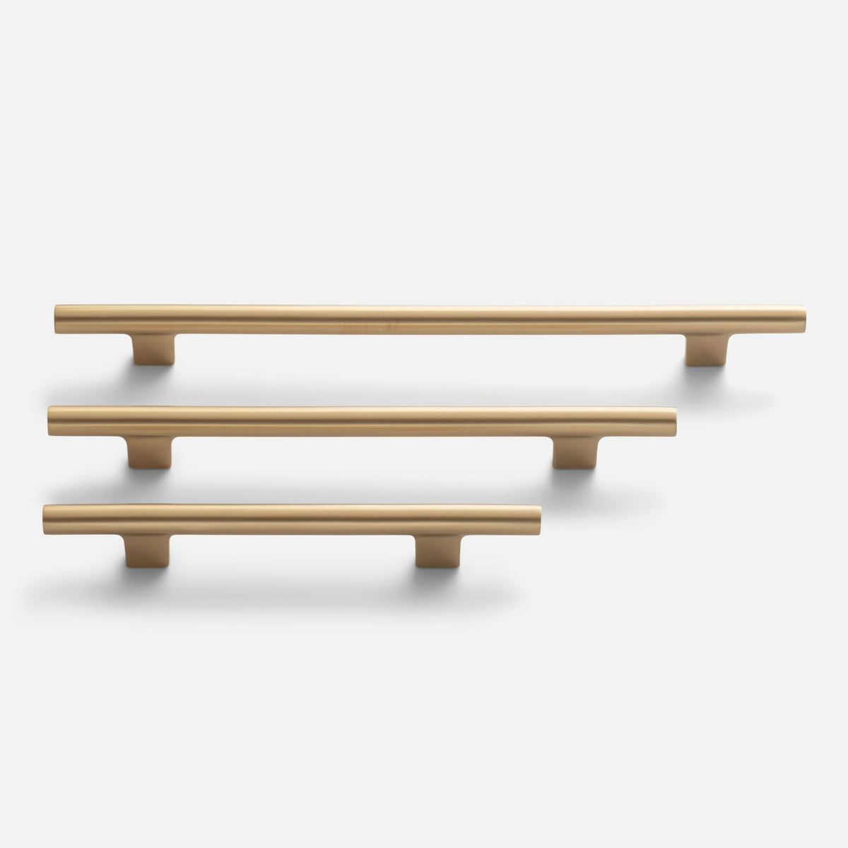 Front view of three Galley Pulls in natural brass showcasing rounded bars and mounting posts on a white background