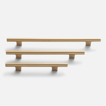 Front view of three Galley Pulls in natural brass showcasing rounded bars and mounting posts on a white background