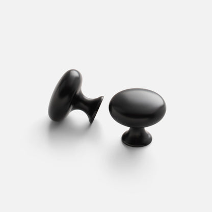 Two views of the Somerset Knob showcasing its egg-shaped silhouette and solid brass construction on a light background