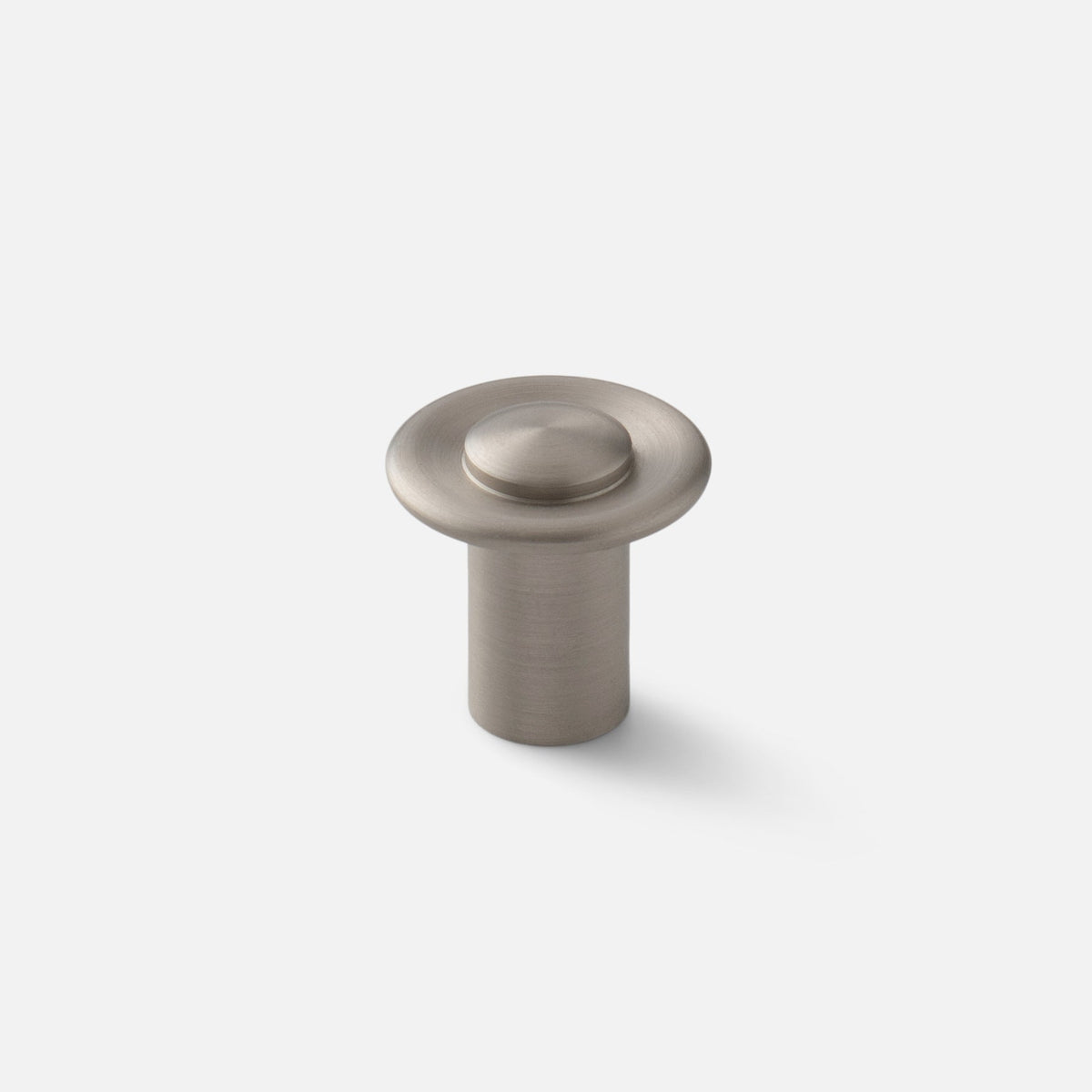 Angled view of Landon Knob showcasing its round raised center and circular base against a light background