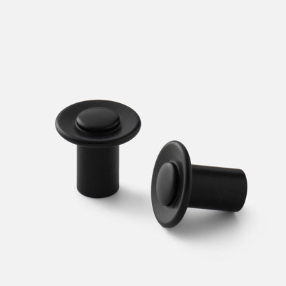 Front and side views of black Landon knobs showcasing round faces and cylindrical bases on a white background
