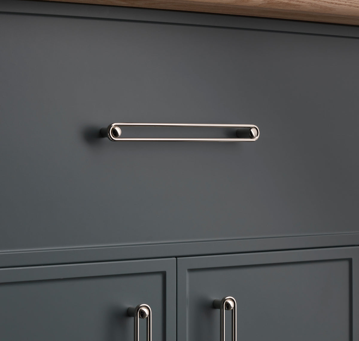 Front view of Landon Pull showcasing its elongated rounded rectangular design on a dark gray cabinet