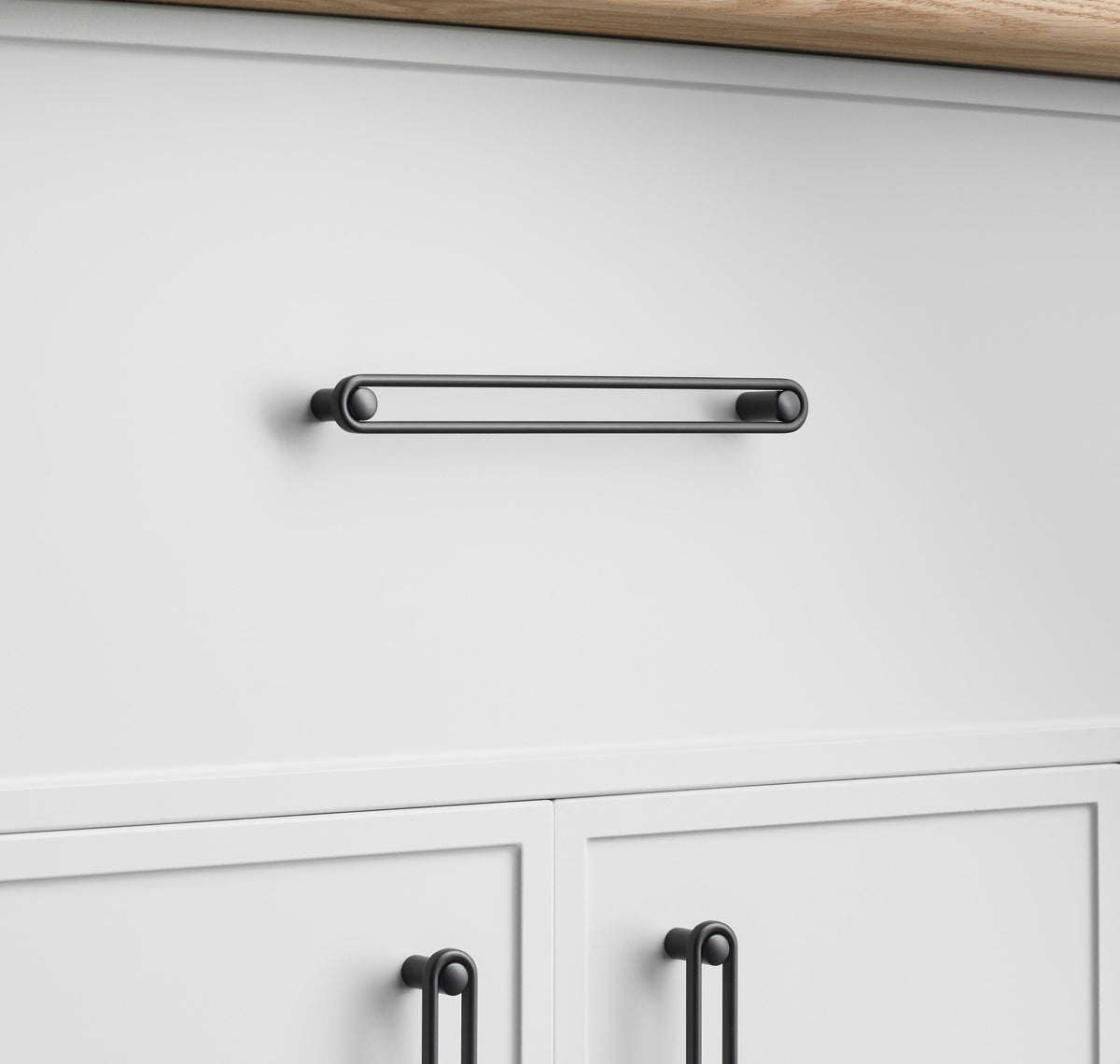 Front view of Landon Pull showcasing its slim rectangular bar design on white cabinetry
