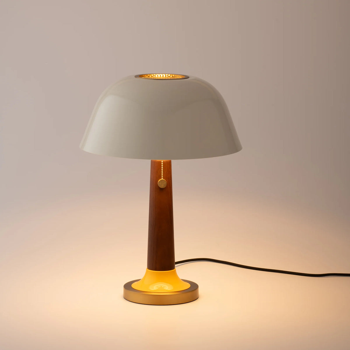 Front view of Evelyn Table Lamp showcasing its perforated brass diffuser and tactile control knob with a warm neutral background