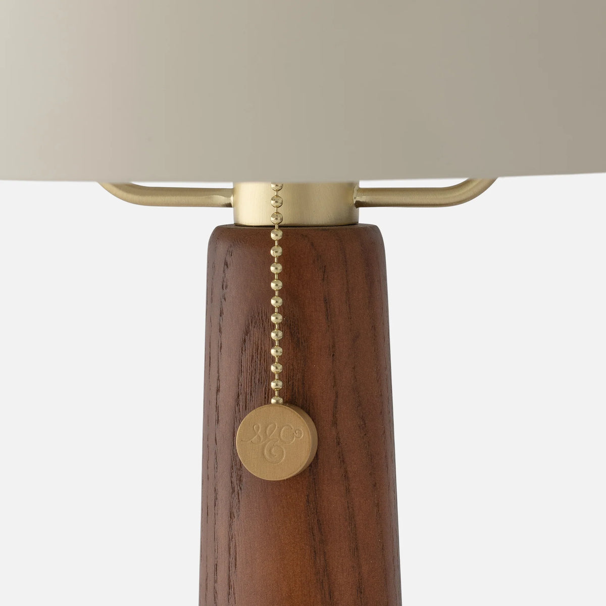 Close-up of Evelyn Table Lamp showcasing wood stem and brass pull chain on a white background