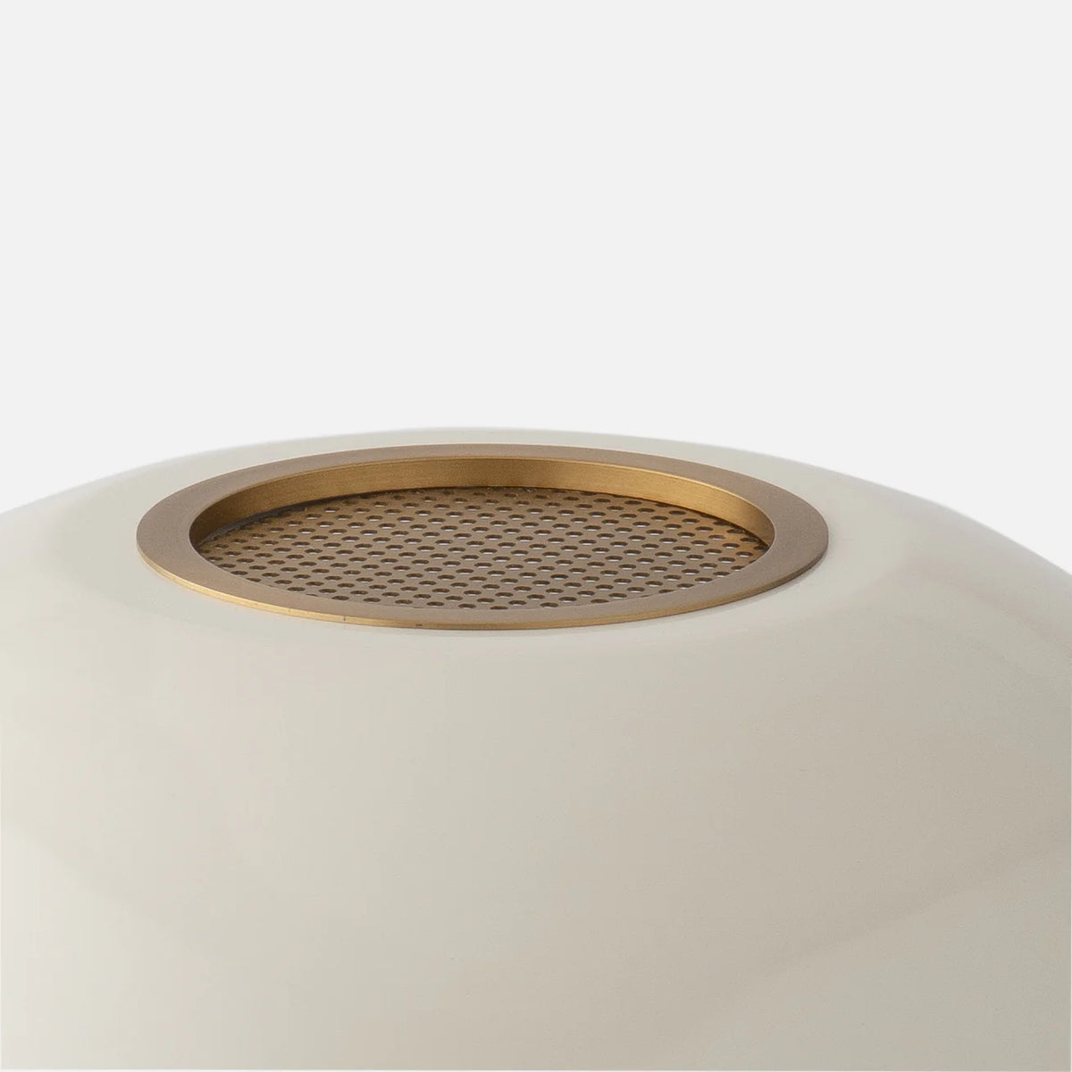 Close-up view of Evelyn Table Lamp showcasing its perforated brass diffuser on a gloss-painted metal shade