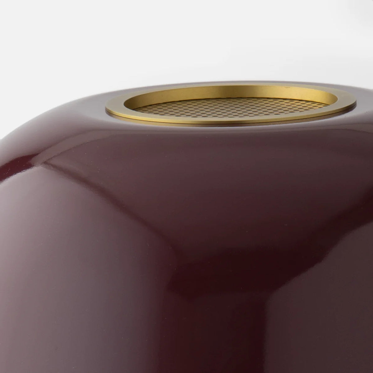 Close-up view of Evelyn Table Lamp showcasing its perforated brass diffuser and gloss-painted metal shade on a white background