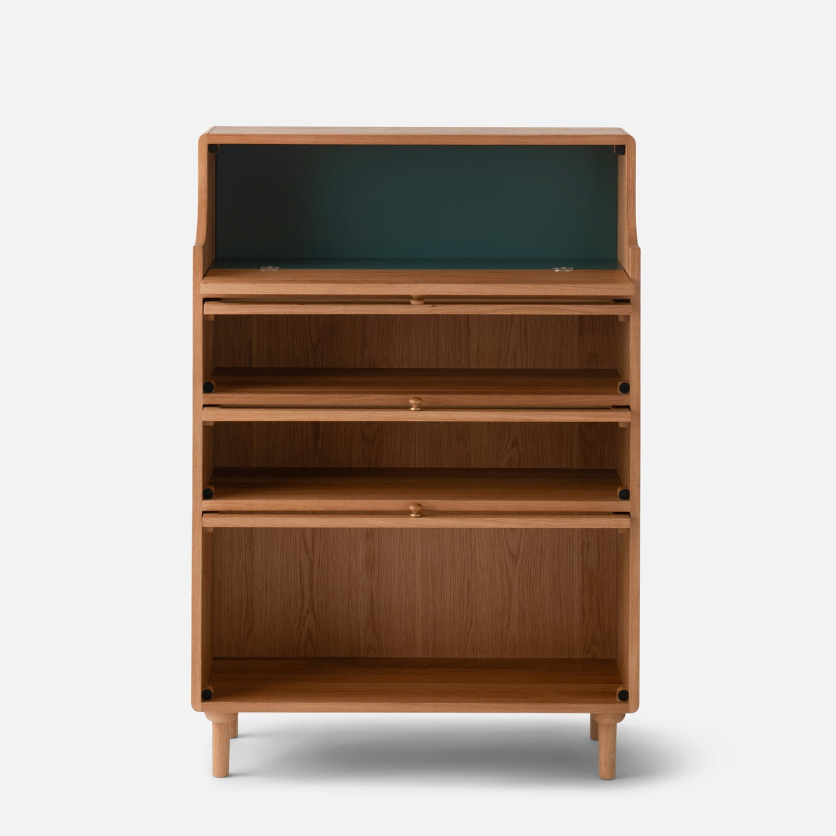 Front view of Peggy Cabinet showcasing multiple open shelves, drawers, and a dark green upper compartment with a light background
