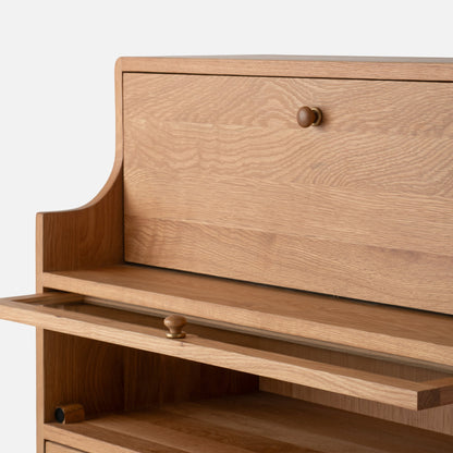 Close-up front view of Peggy Cabinet showcasing natural wood grain, rounded edges, and brass knobs against a white background