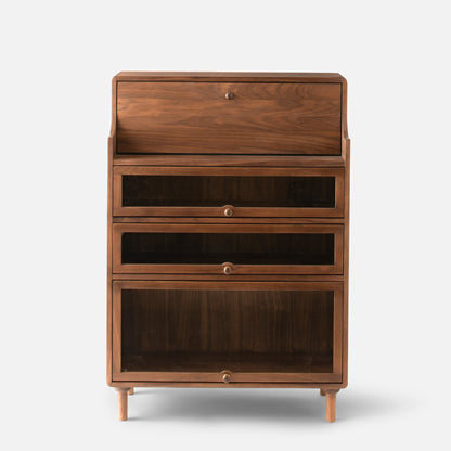 Front view of Peggy Cabinet showcasing four stacked storage compartments, round knobs, and tapered legs against a white background