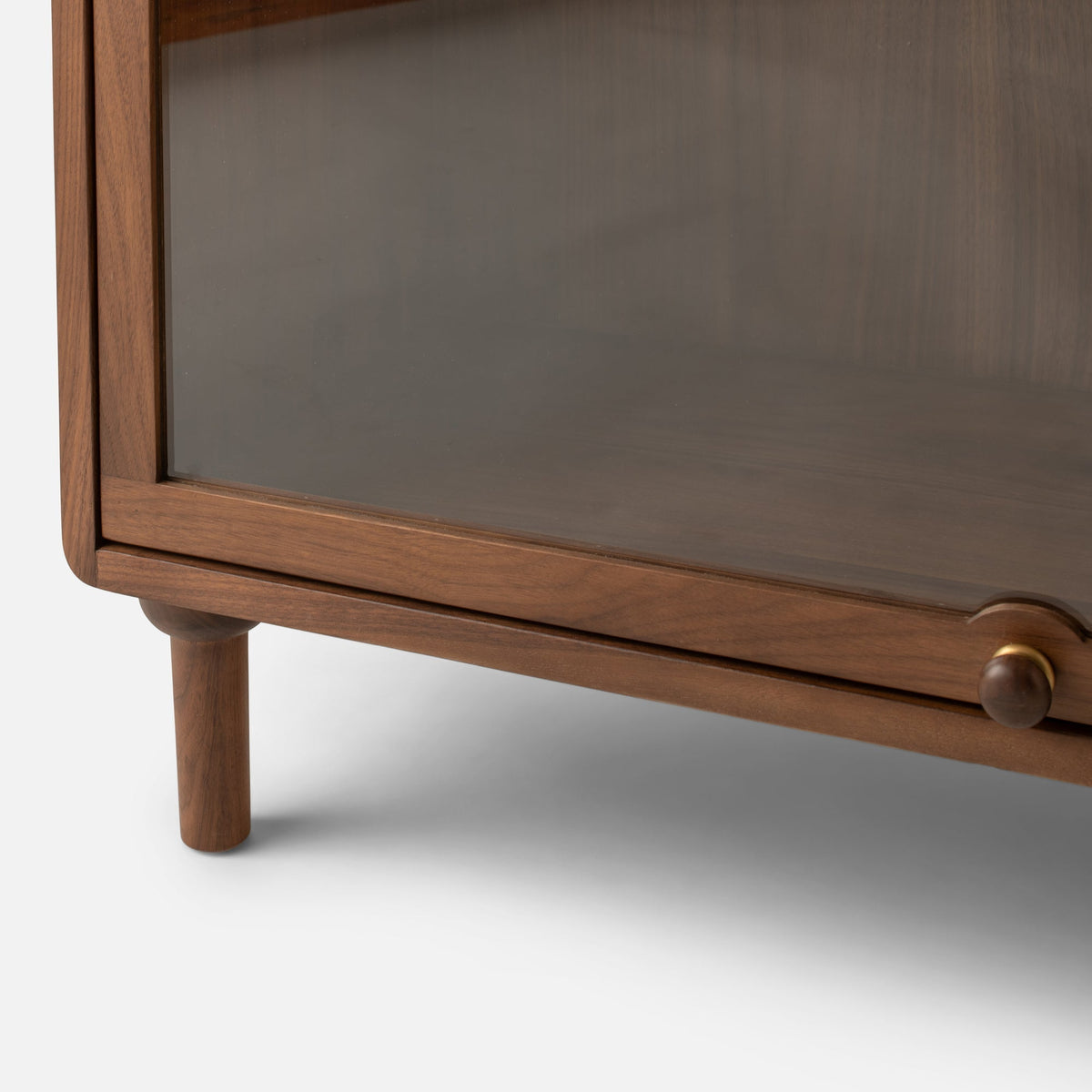 Close-up front view of Peggy Cabinet showcasing wood-grain frame, glass door, and round knob on white background