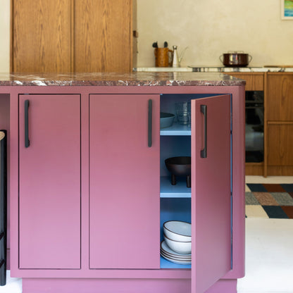 Front view of Roland Pull showcasing its long bar design on pink kitchen cabinetry with an open door
