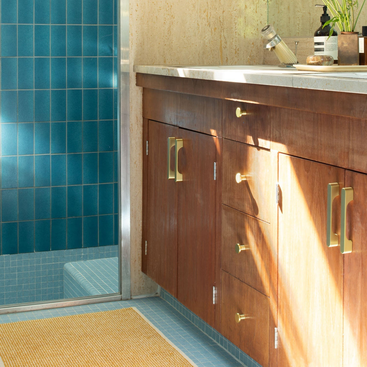 Front view of natural brass Roland Pull cabinet hardware showcasing solid-brass finish on a wood bathroom vanity