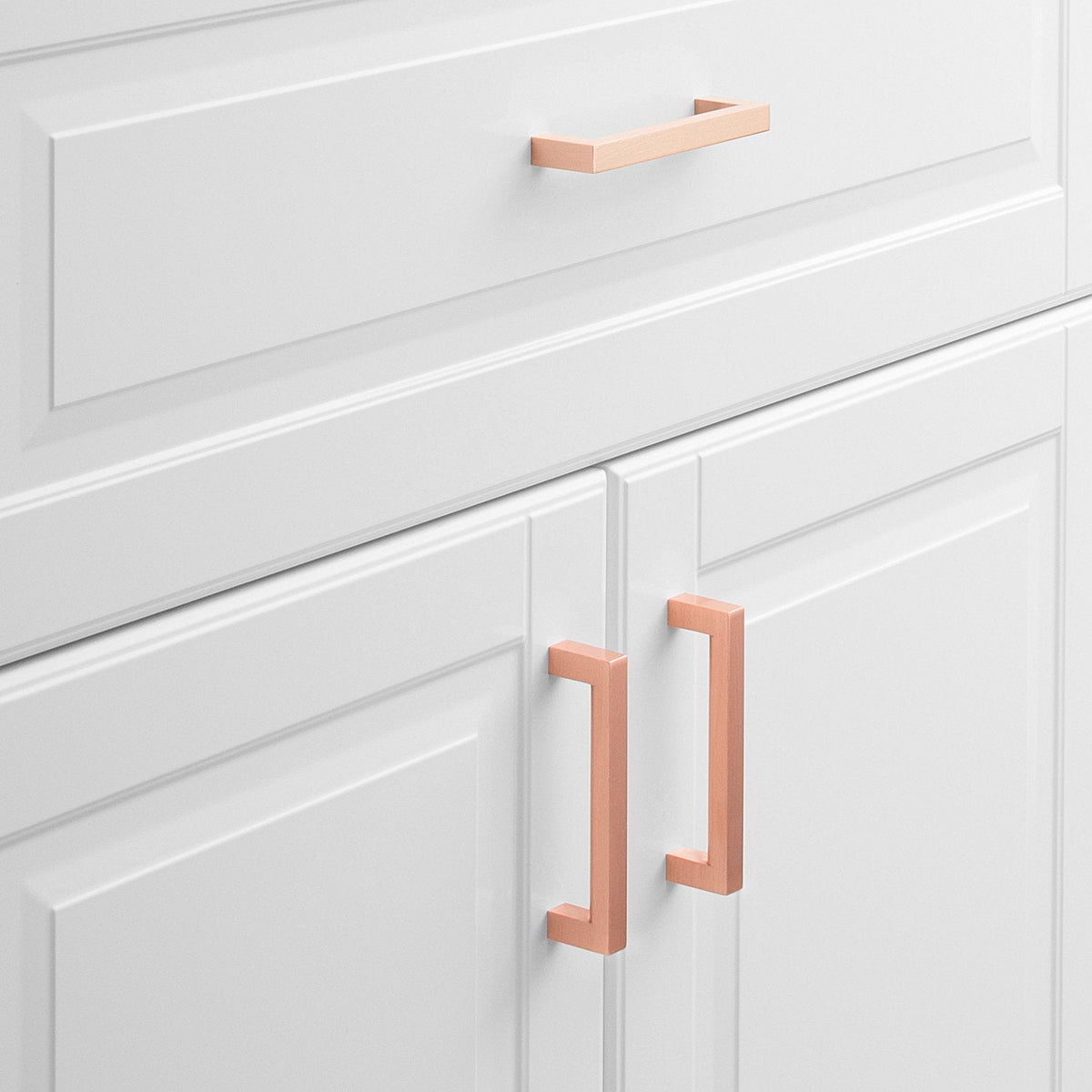 Front view of Edgecliff Pull showcasing elongated rectangular handles on white paneled cabinets