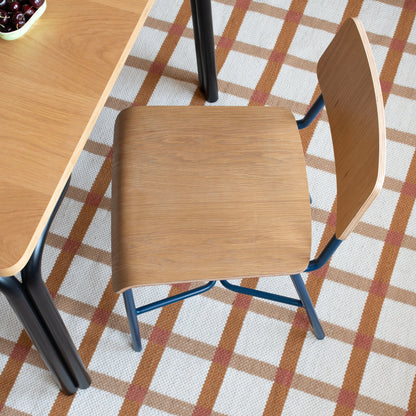 Overhead view of Cole Dining Chair showing contoured oak veneer seat and backrest with powder-coated metal frame on a rug