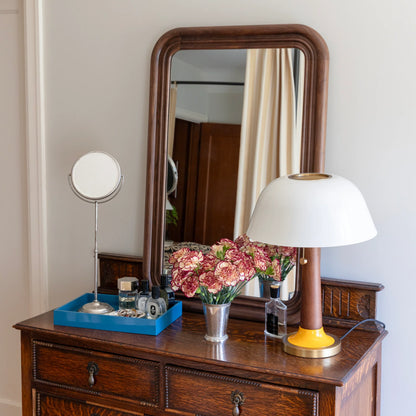 Front view of Evelyn Table Lamp showcasing its mushroom silhouette, brass accents, and gloss-painted shade on a dresser