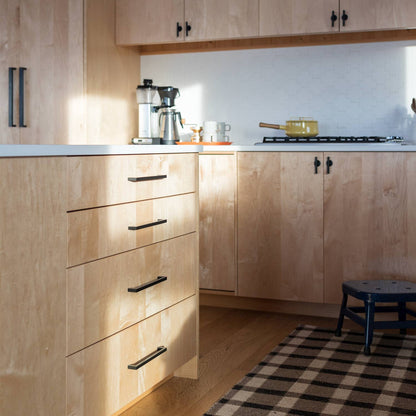 Edgecliff Appliance Pulls installed on light wood kitchen cabinets in a sunlit kitchen