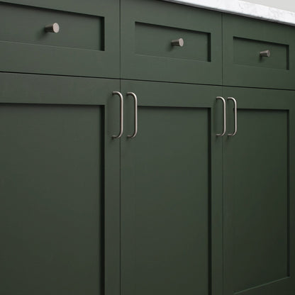 Close-up of Parker Pull showcasing curved handles installed on dark green paneled cabinets