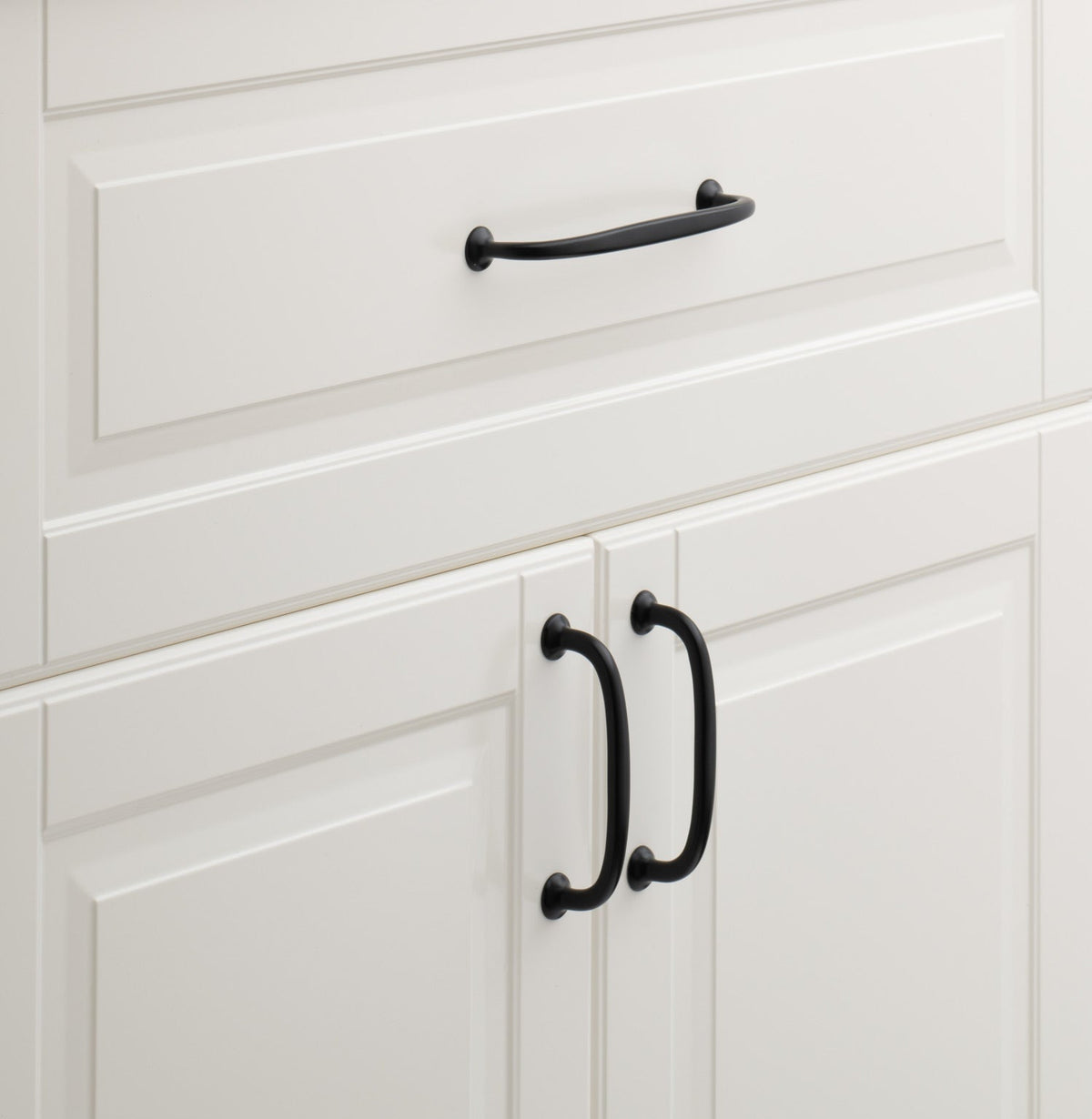 Close-up view of Somerset Appliance Pull showcasing black curved handles on white paneled cabinetry